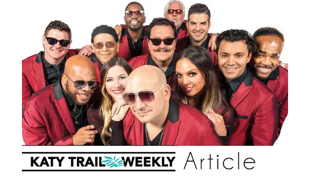 Group of people in red jackets smiling together, some wearing sunglasses.