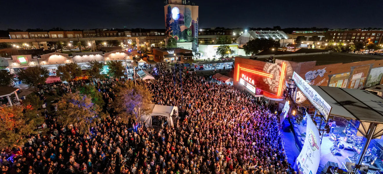 Arial view of a large crowd watching a band play at night