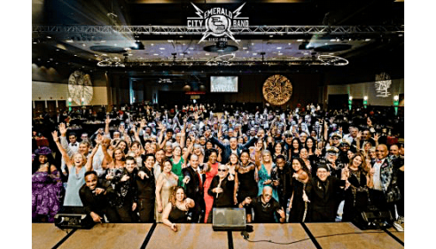 Large group of people posing and smiling in a conference hall.