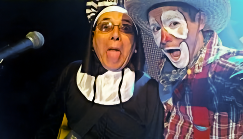 Person in a nun costume poses with a smiling clown in plaid shirt and cowboy hat.