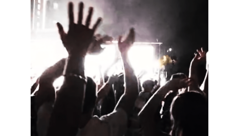 Hands in the air in front of a stage