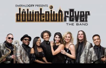 Eight band members posing together in coordinated black and silver outfits.