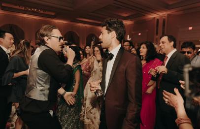 People dancing and celebrating at a formal indoor party.