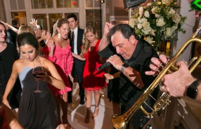 People dancing and enjoying live music at a lively indoor party.