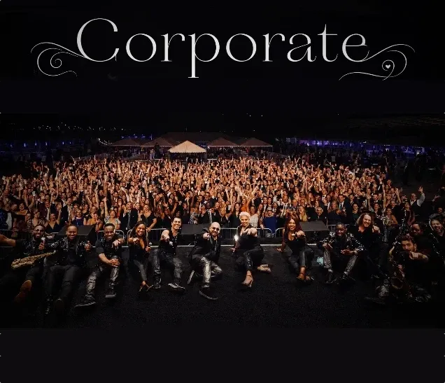 Large group of people posing together at a nighttime corporate event.