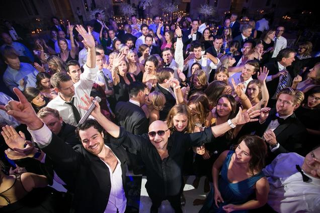 Crowd of people dancing and celebrating at a lively indoor party.