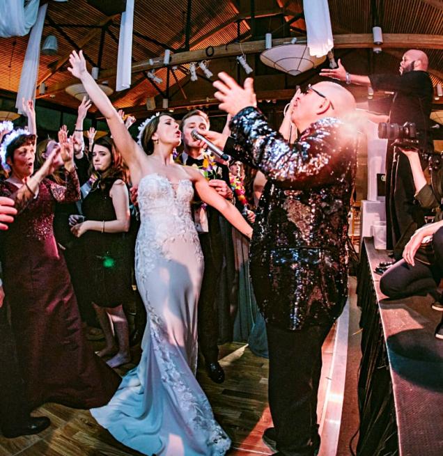 Bride dancing joyfully with guests on a lively wedding dance floor.