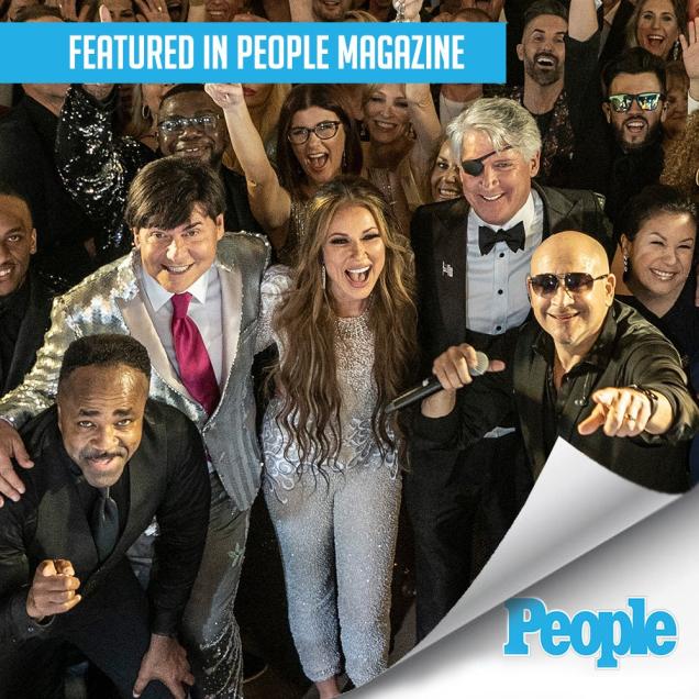 Group of smiling people in formal wear, posing together at an event, People Magazine logo.