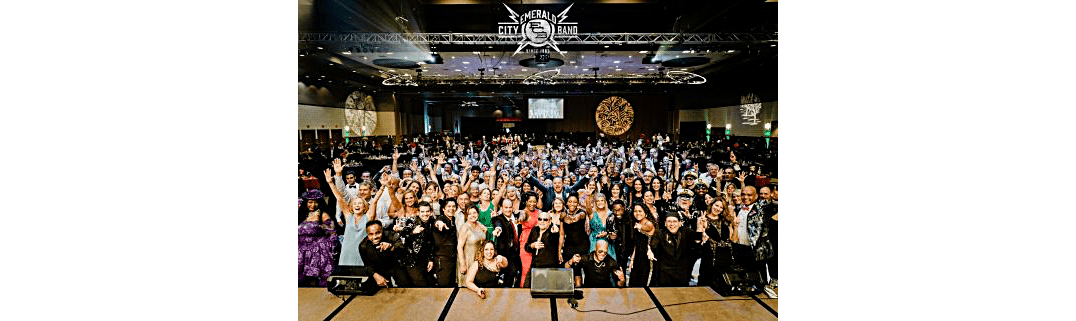 Large group of people posing and smiling in a conference hall.
