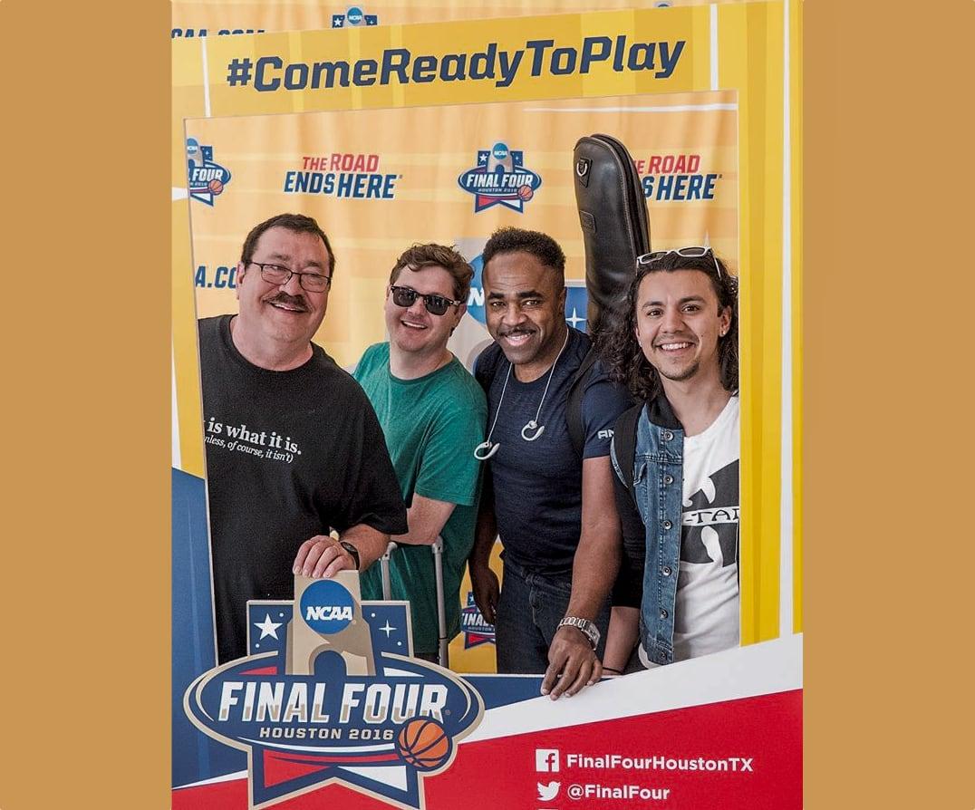 Four smiling men pose together at an NCAA Final Four Houston 2023 basketball event display.