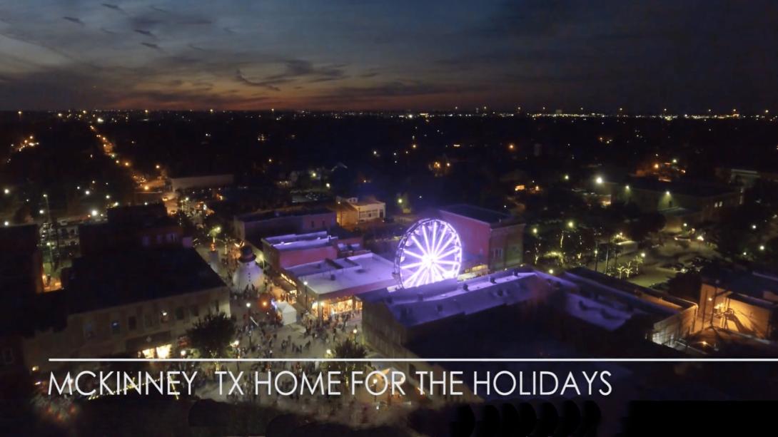 Arial photo of a town at night with a ferris wheel