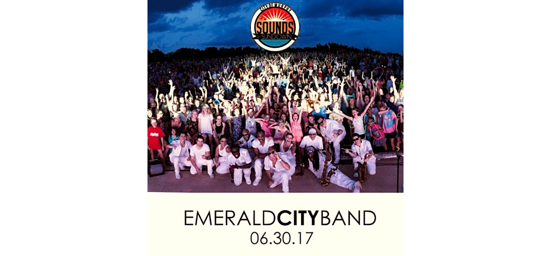 Large crowd cheering outdoors at dusk with Emerald City Band and event date text below.