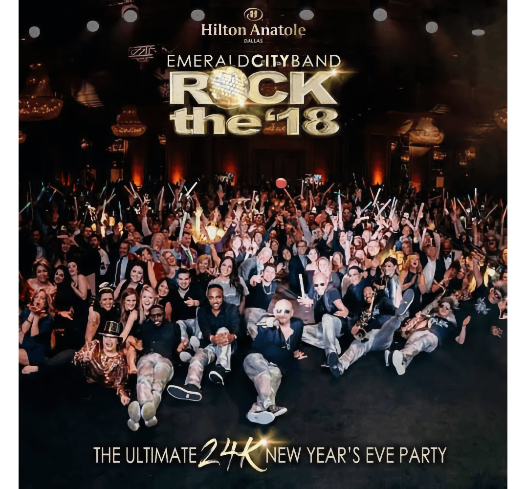 Large crowd celebrating at a New Year's Eve party with festive lights and band on stage.