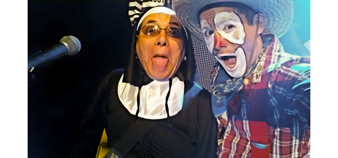 Person in a nun costume poses with a smiling clown in plaid shirt and cowboy hat.