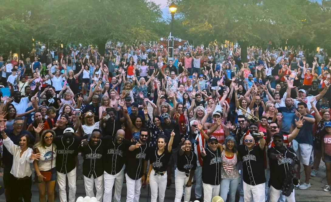 Members of Emerald City Band standing in front of a large crowd
