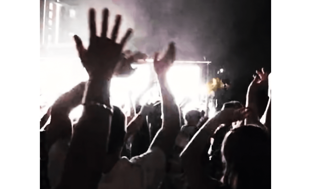 Hands in the air in front of a stage